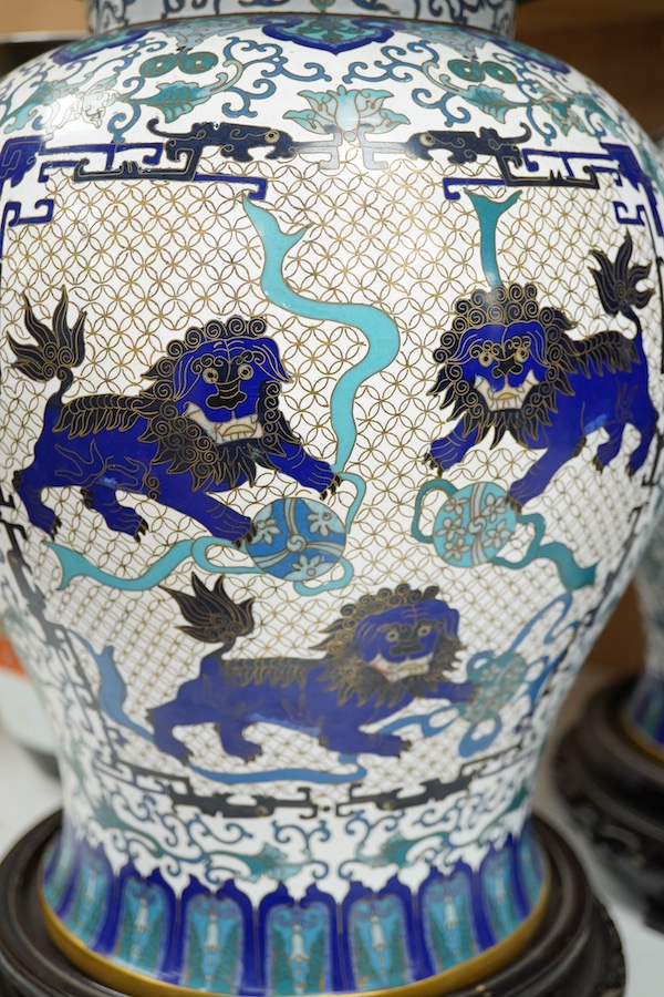 A pair of Chinese blue and white dragon decorated cloisonné enamel jars and covers on stands, 45cm high and a Japanese enamelled porcelain vase, early 20th century. (3). Condition - good